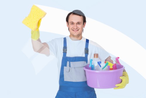 Carpet cleaning technician preparing equipment with safety precautions in Ardleigh Green